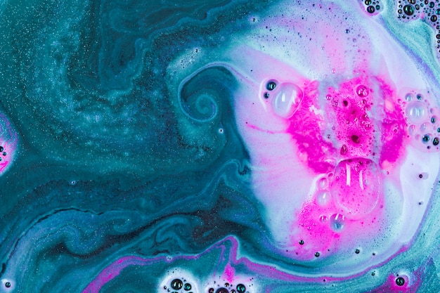 Bomba de baño rosa en extracto de agua verde, fondo, textura, manchas