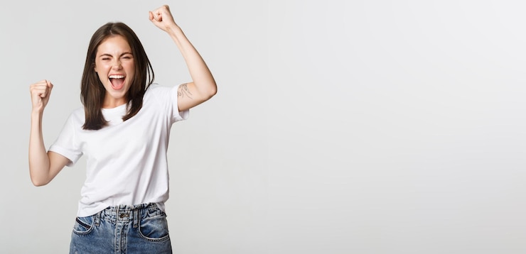 Foto gratuito bomba de puño de chica morena atractiva alegre y sonriendo con regocijo ganando