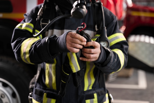 Bombero en la estación equipado con traje protector y máscara contra incendios.