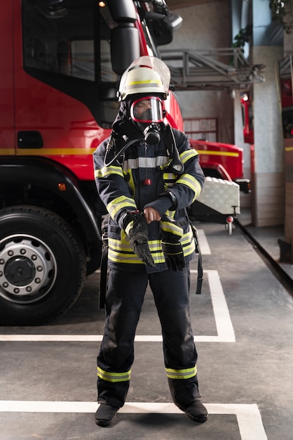 Bombero en la estación equipado con traje protector y máscara contra incendios.