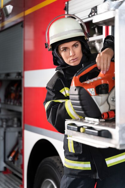 Bombero femenino en la estación equipada con traje y casco de seguridad