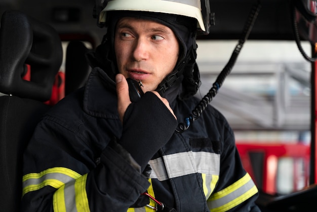 Bombero masculino en camión de bomberos con estación de radio