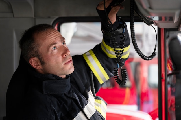 Foto gratuita bombero masculino en la estación dentro del camión de bomberos