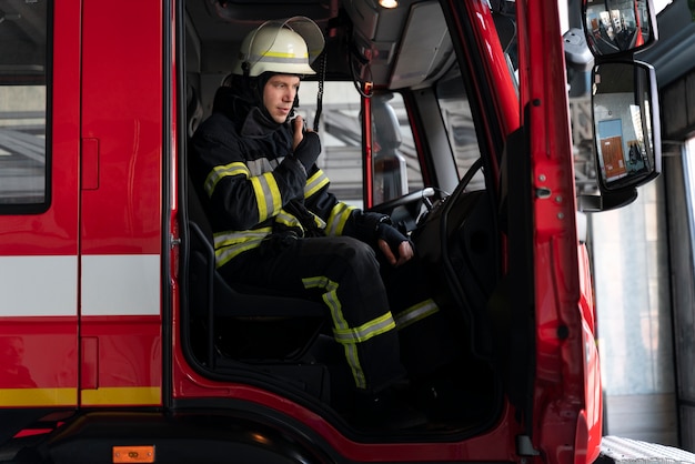 Bombero masculino en la estación equipada con traje y casco de seguridad