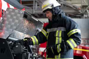 Foto gratuita bombero masculino en la estación equipada con traje y casco de seguridad