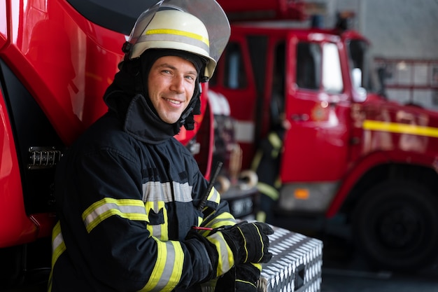 Foto gratuita bombero masculino en la estación en traje y casco