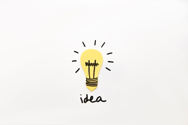 Bombilla iluminada con la palabra idea sobre fondo negro