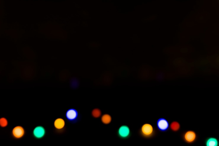 Foto gratuito bombillas desenfocadas de colores sobre un fondo negro