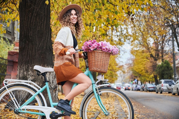 Bonita ciclista femenina en la calle con bicicleta de mujer