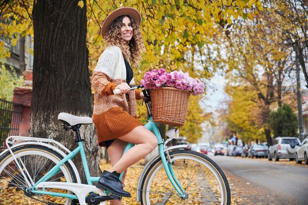 Bonita ciclista femenina en la calle con bicicleta de mujer