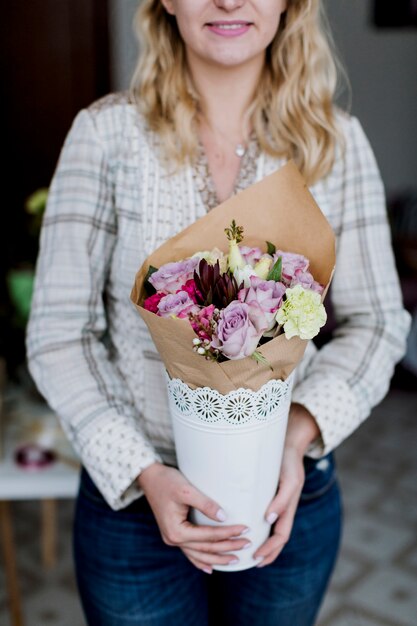 Bonita florista con ramo de flores