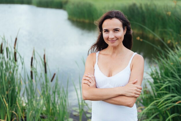 Bonita madre posando junto al lago.