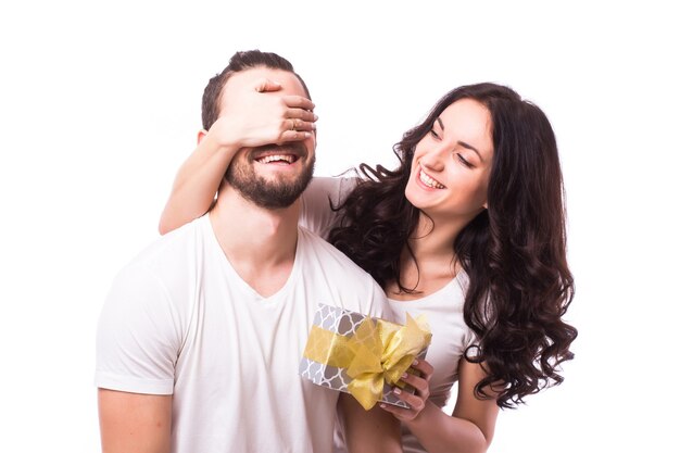 Bonita morena sorprendente novio con un regalo sobre fondo blanco.