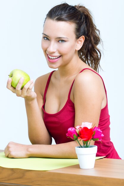 Bonita mujer comiendo una manzana verde