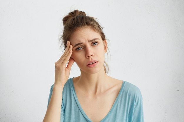 Foto gratuita bonita mujer con ojos azules con la mano en la cabeza.