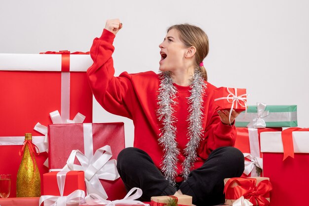 Bonita mujer sentada alrededor de regalos de Navidad en blanco