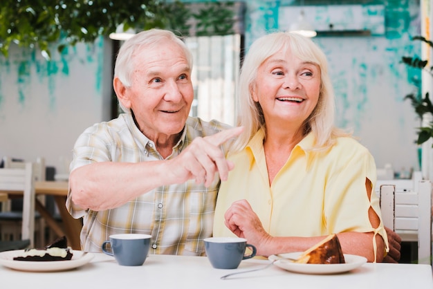 Bonita pareja de ancianos mirando a otro lado con una sonrisa