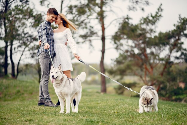 Bonita pareja en un bosque de verano con perros.