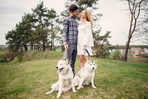 Bonita pareja en un bosque de verano con perros.