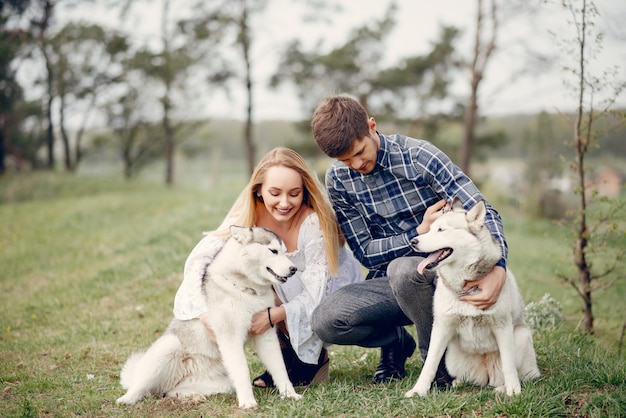 Bonita pareja en un bosque de verano con perros.