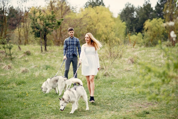 Bonita pareja en un bosque de verano con perros.