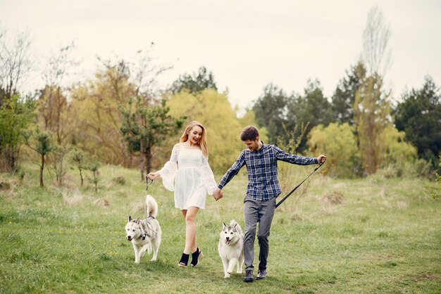 Bonita pareja en un bosque de verano con perros.