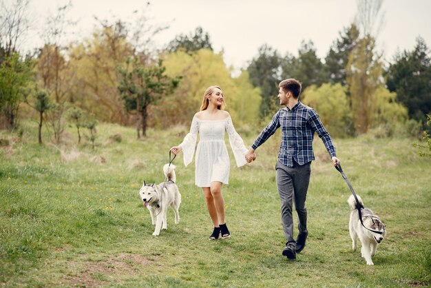 Bonita pareja en un bosque de verano con perros.