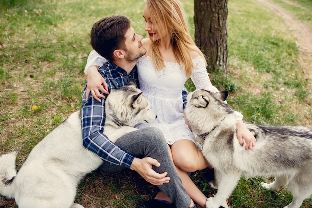 Bonita pareja en un bosque de verano con perros.