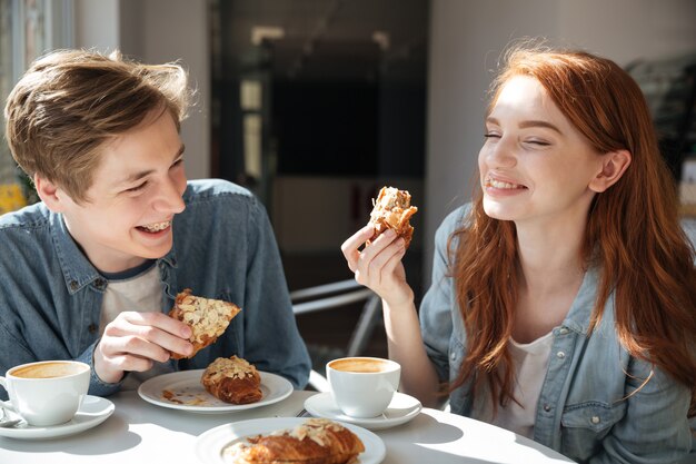 Bonita pareja comiendo en la cafetería