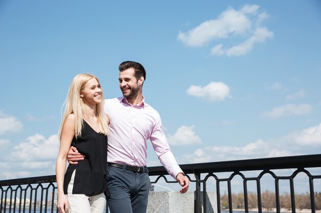 Bonita pareja de hombre alegre y una mujer caminando en la calle