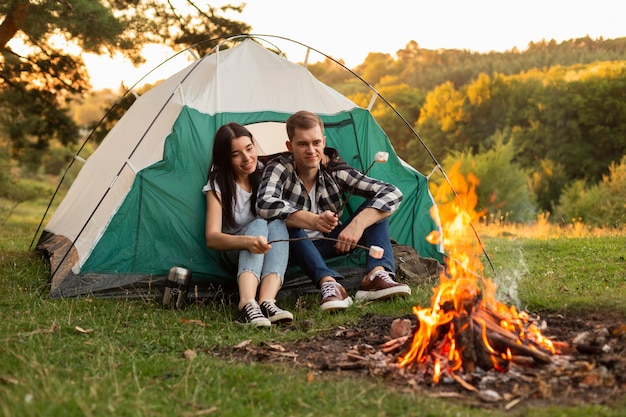 Foto gratuita bonita pareja joven disfrutando de la hoguera