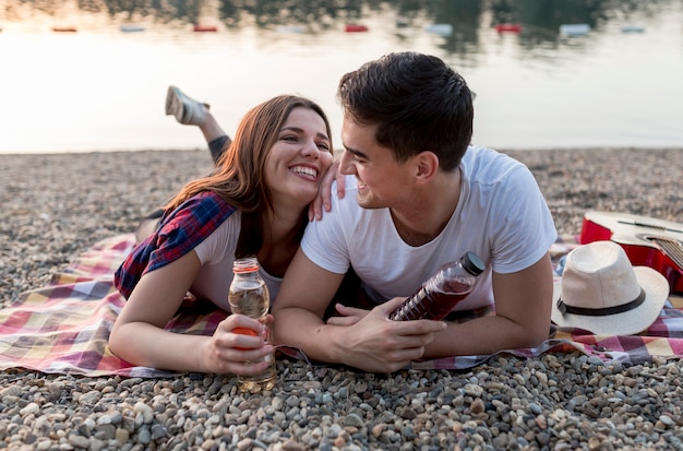 Bonita pareja joven divirtiéndose en el lago