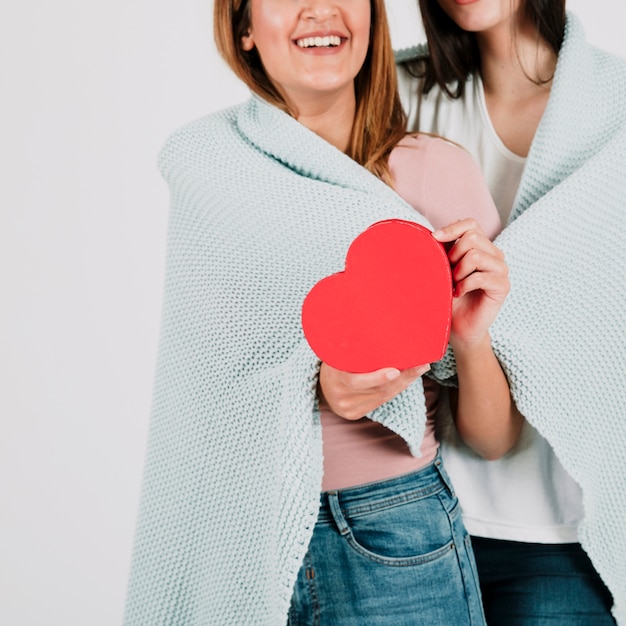 Foto gratuita bonita pareja de lesbianas con corazón en manta