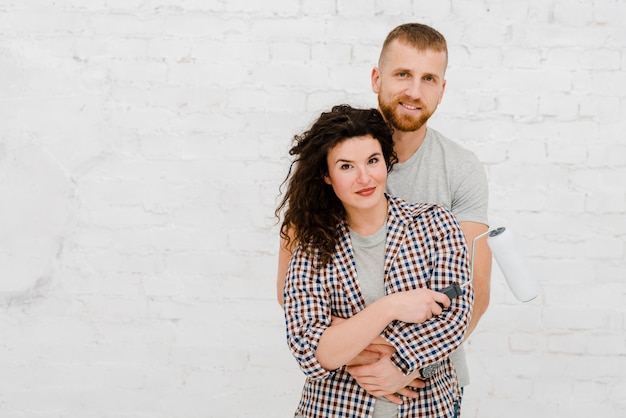 Foto gratuita bonita pareja con rodillo de pintura