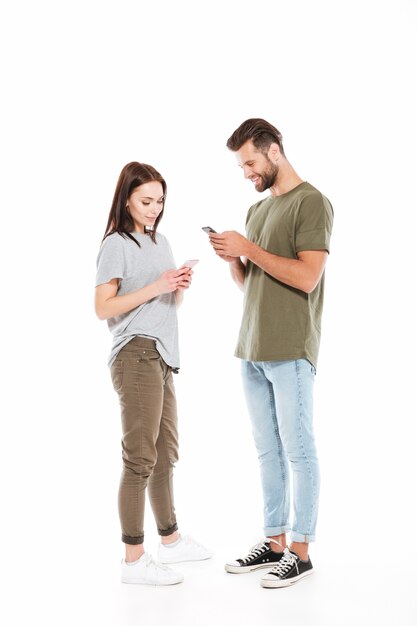 Bonita pareja usando teléfonos inteligentes