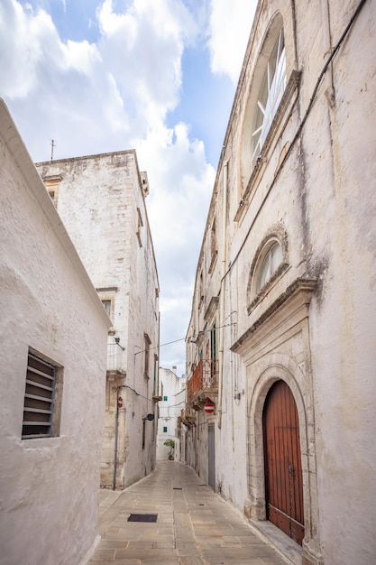 Bonita vista de las calles vacías del casco antiguo de martina franca con hermosas casas encaladas. maravilloso día en una ciudad turística, apulia, italia.