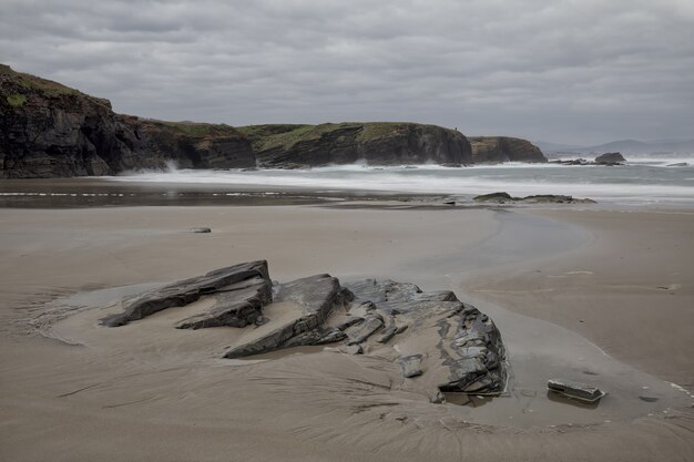 Bonita vista de la hermosa playa de Os Castros capturada en un día nublado en Ribadeo, Galicia, España