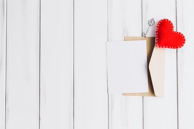 Bonito corazón en un sobre con papel en blanco