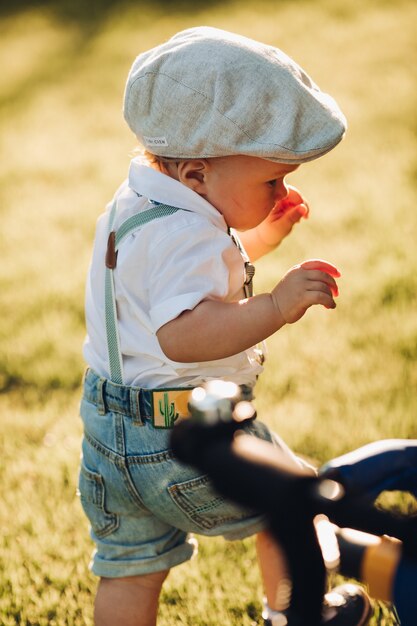 Bonito niño caucásico con ropa elegante camina al jardín con los padres