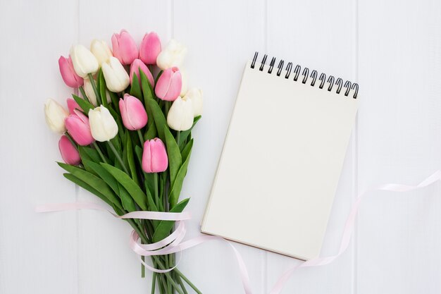 Bonito ramo de flores de tulipanes con cuaderno vacío.