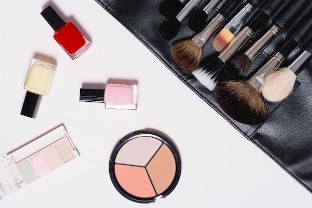 Foto gratuita bonitos cosméticos cerca del kit de pinceles de maquillaje