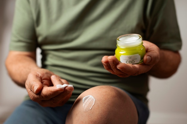 Foto gratuita los boomers que usan aceite y crema de cbd para tratar el dolor corporal