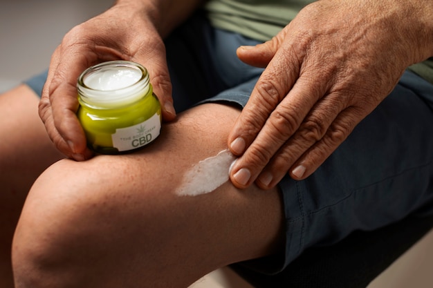 Foto gratuita los boomers que usan aceite y crema de cbd para tratar el dolor corporal