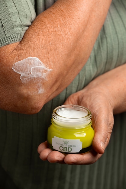 Foto gratuita los boomers que usan aceite y crema de cbd para tratar el dolor corporal