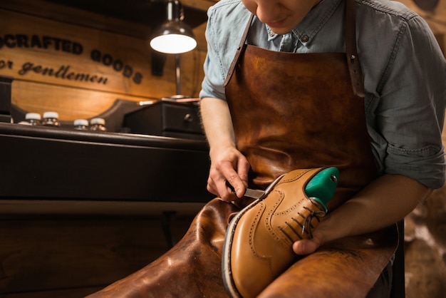 Foto gratuita bootmaker en taller haciendo zapatos