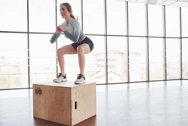 En el borde de la caja. Deportiva joven tiene día de fitness en el gimnasio por la mañana