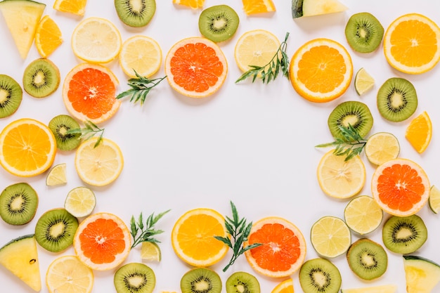 Foto gratuita borde de hojas y frutas en rodajas