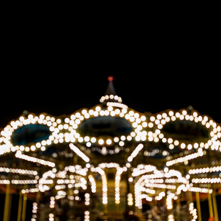Foto gratuito un borroso carrusel iluminado en el parque de atracciones en la noche