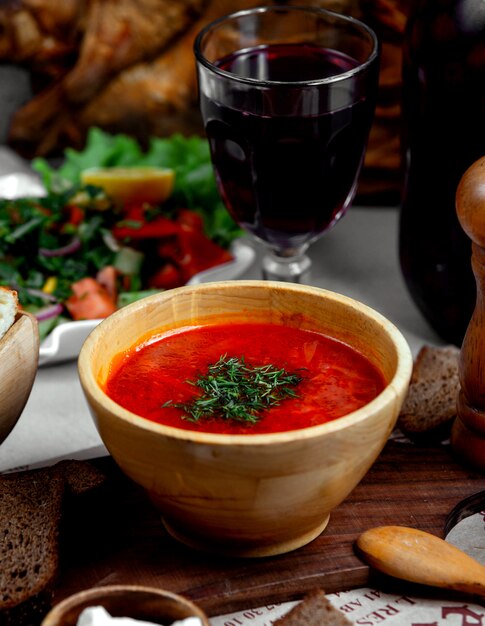 Borsch con hierbas y copa de vino.