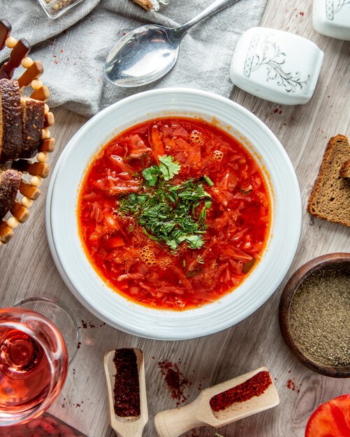 borscht tradicional ucraniano con rebanadas de pan integral y un refresco